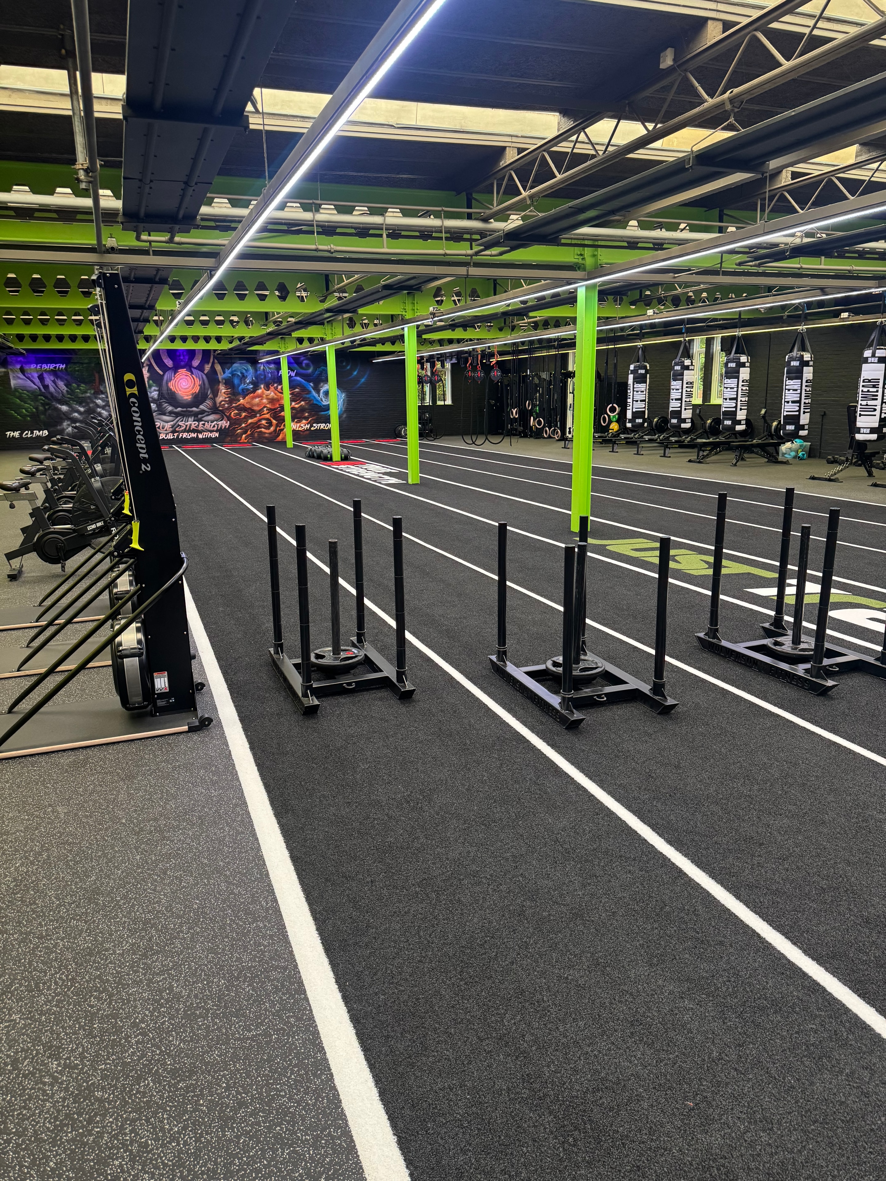 Just Train gym space with sled track and equipment